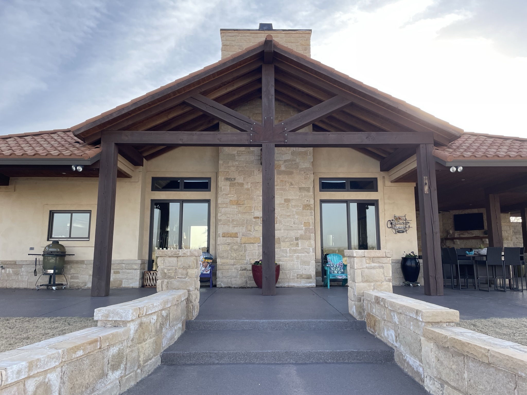 Custom pergola built over a backyard patio seating area