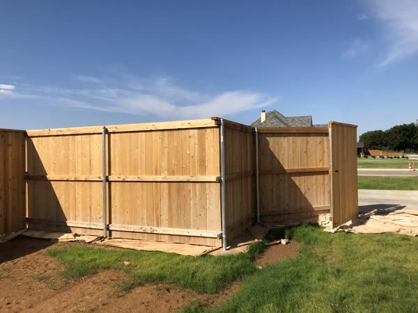 Long stained wood privacy fence next to a home